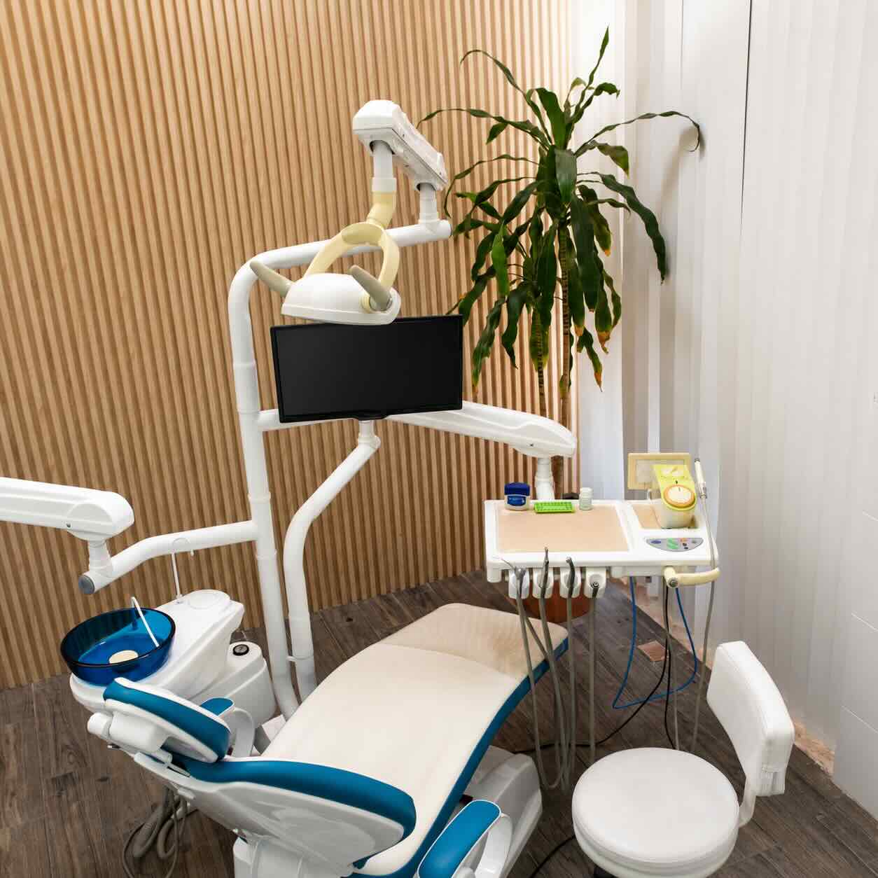 Consultorio dental moderno en Cancún con sillón odontológico y muro de madera